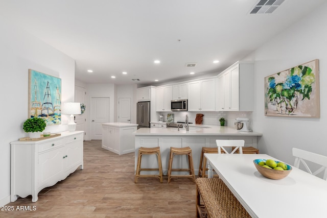 2511 W Queen Creek Rd Unit 174, Chandler, AZ 85248 - kitchen with appliances with stainless steel finishes, a peninsula, white cabinetry, a sink, and recessed lighting