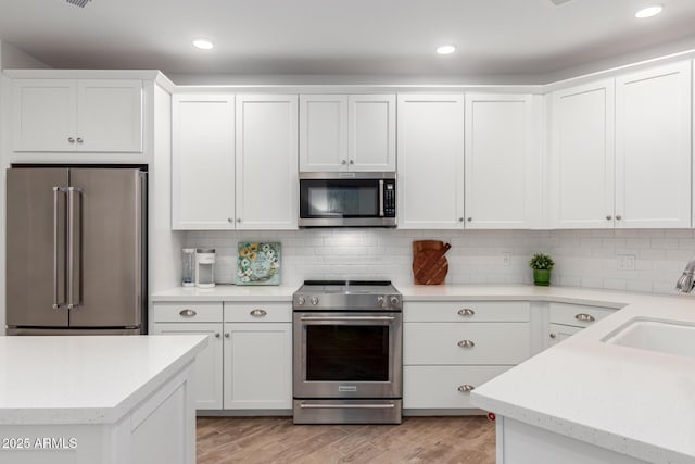 2511 W Queen Creek Rd Unit 174, Chandler, AZ 85248 - kitchen with appliances with stainless steel finishes, a sink, white cabinetry, light wood-style floors, and recessed lighting