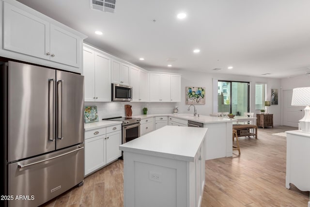 2511 W Queen Creek Rd Unit 174, Chandler, AZ 85248 - kitchen with appliances with stainless steel finishes, a peninsula, a sink, a center island, and light countertops