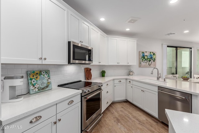 2511 W Queen Creek Rd Unit 174, Chandler, AZ 85248 - kitchen with stainless steel appliances, a sink, white cabinetry, decorative backsplash, and recessed lighting