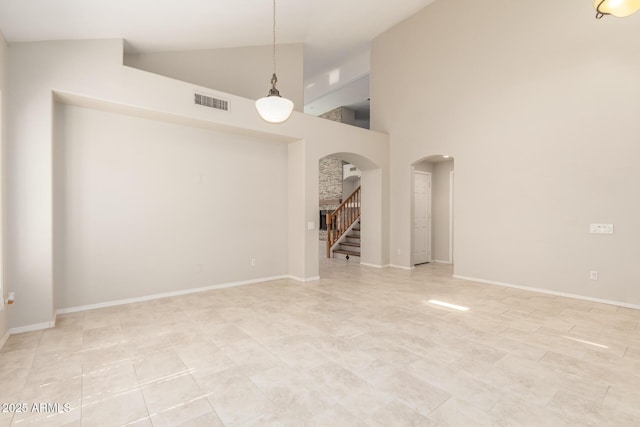 4801 E Quien Sabe Way, Cave Creek, AZ 85331 - unfurnished room featuring arched walkways, high vaulted ceiling, stairway, and baseboards