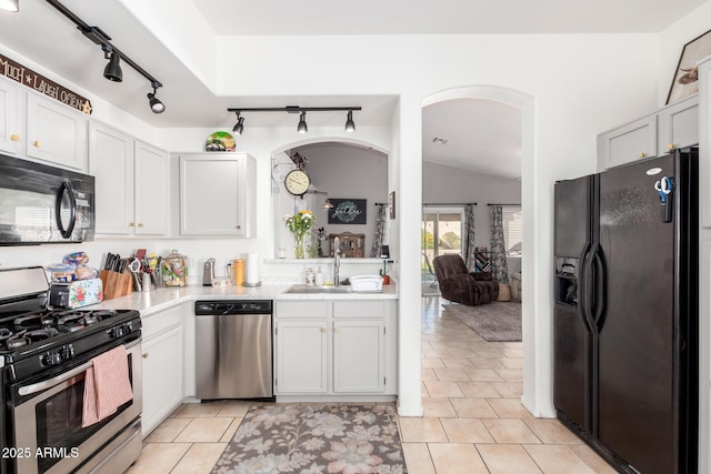 kitchen featuring lofted ceiling, black appliances, white cabinets, and light countertops