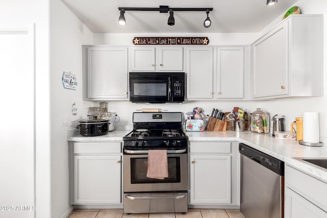 kitchen featuring light tile patterned floors, appliances with stainless steel finishes, and white cabinets