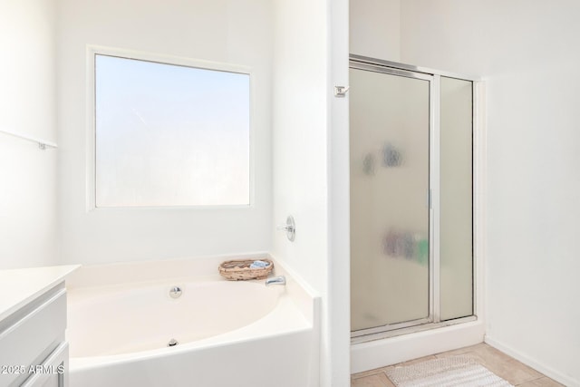 full bath featuring a bath, tile patterned flooring, a stall shower, and vanity