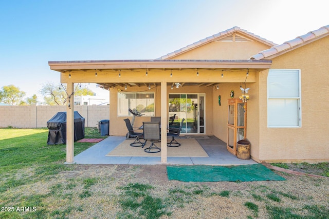 exterior space with a patio area, fence, a lawn, and stucco siding