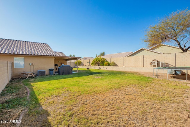 view of yard featuring a fenced backyard, central air condition unit, and a trampoline