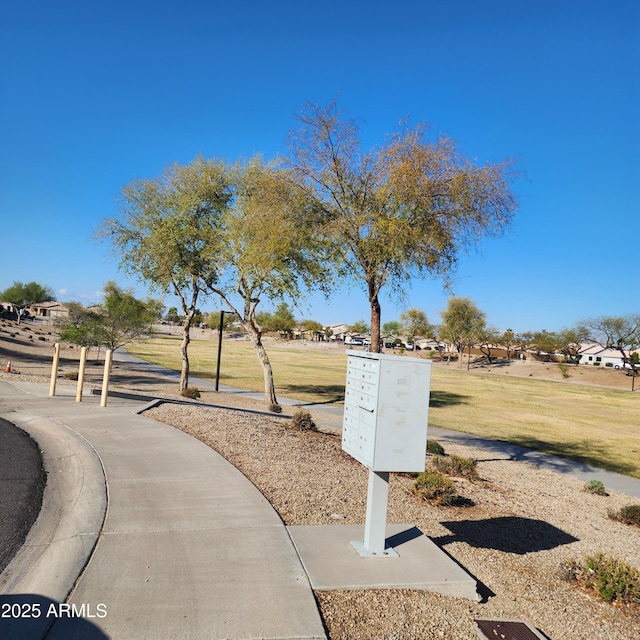 view of home's community featuring mail area and a lawn