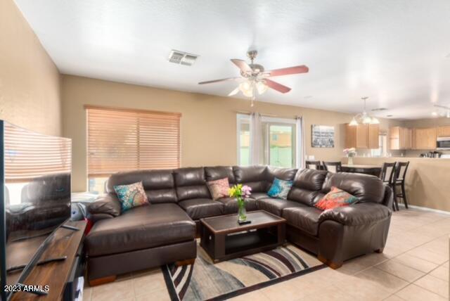 living room featuring light tile patterned floors and ceiling fan