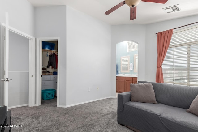 1350 S Greenfield Rd Unit 1005, Mesa, AZ 85206 - living area featuring ceiling fan, carpet flooring, arched walkways, and baseboards