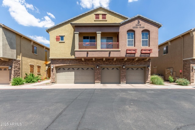 1350 S Greenfield Rd Unit 1005, Mesa, AZ 85206 - townhome / multi-family property with a balcony, stucco siding, a garage, and stone siding
