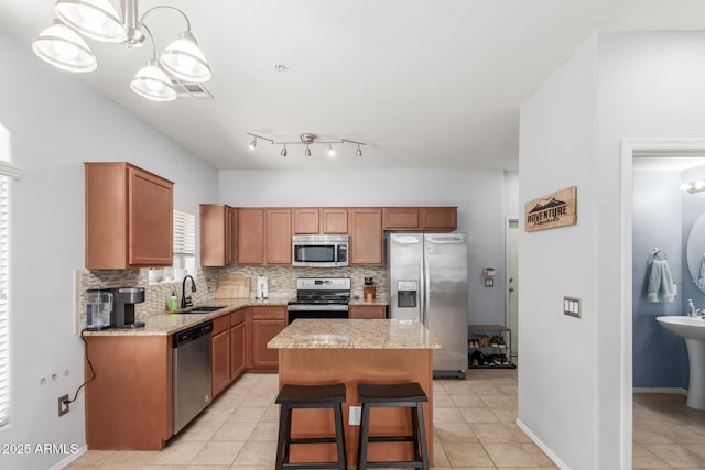 1350 S Greenfield Rd Unit 1005, Mesa, AZ 85206 - kitchen featuring appliances with stainless steel finishes, a sink, tasteful backsplash, a kitchen island, and light tile patterned floors