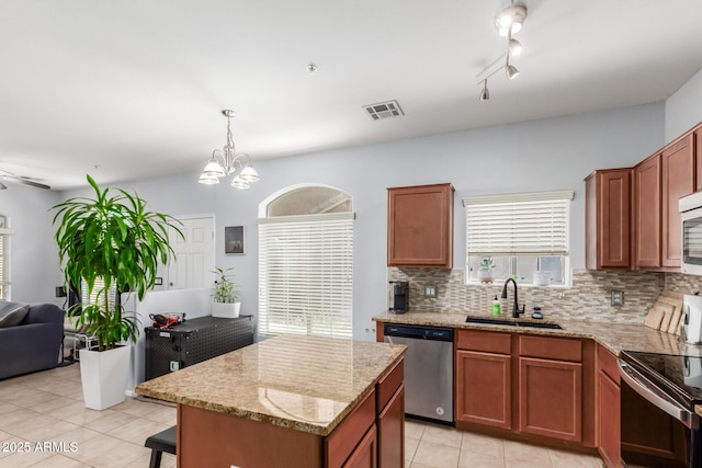 1350 S Greenfield Rd Unit 1005, Mesa, AZ 85206 - kitchen with stainless steel appliances, a sink, light tile patterned floors, tasteful backsplash, and light stone counters