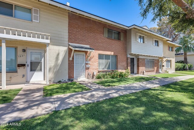 townhome / multi-family property with a front yard