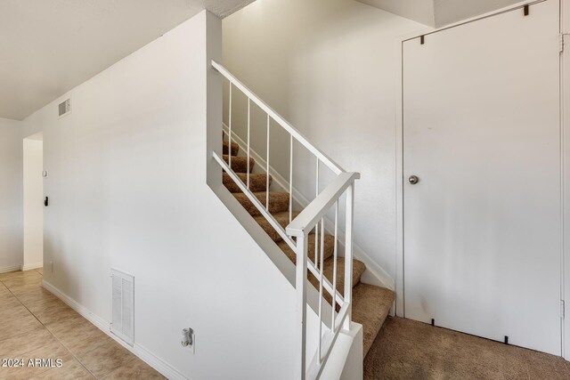 stairway with tile patterned flooring