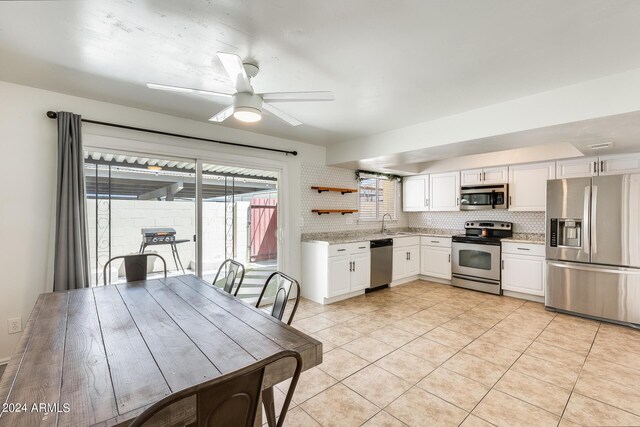 kitchen featuring stainless steel appliances, white cabinetry, sink, ceiling fan, and tasteful backsplash