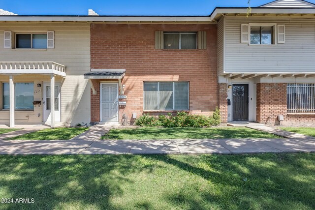 townhome / multi-family property featuring a front yard