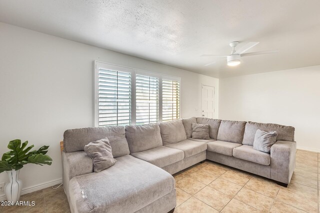 tiled living room with a textured ceiling and ceiling fan