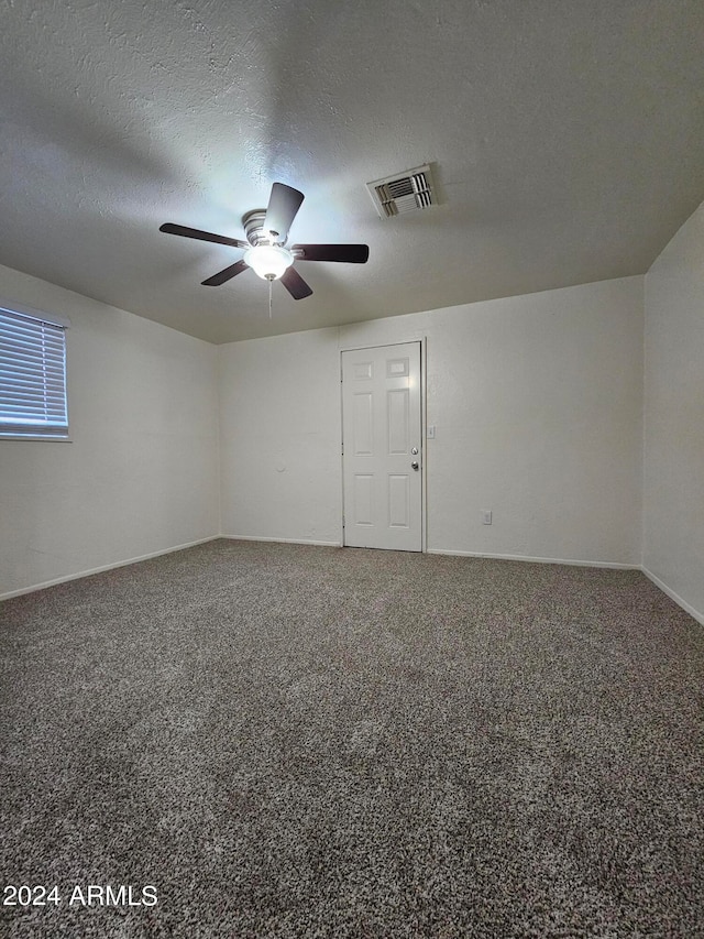 carpeted spare room featuring a textured ceiling and ceiling fan