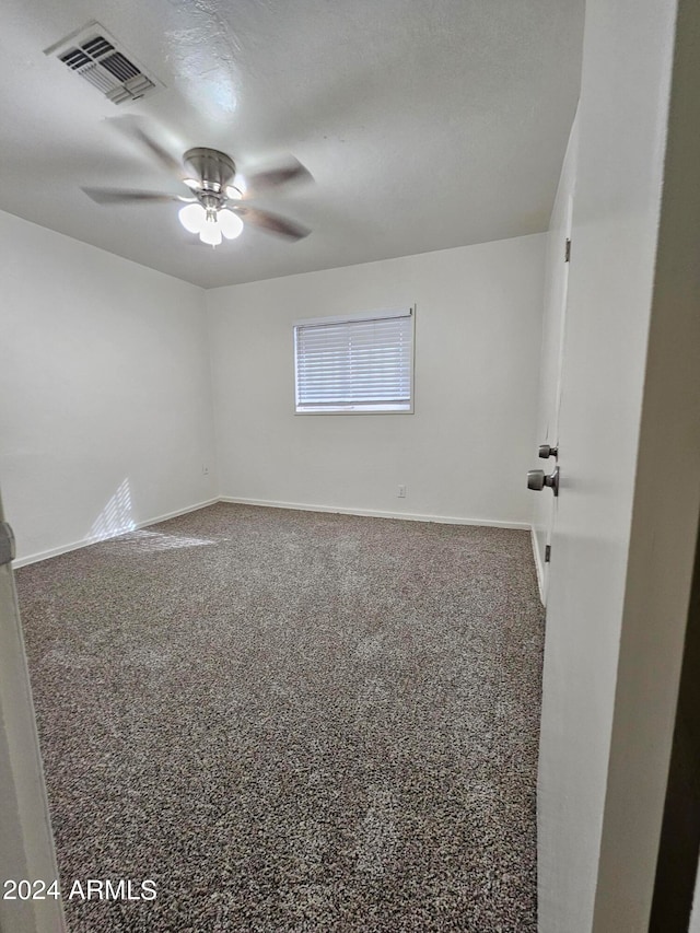 carpeted spare room with ceiling fan