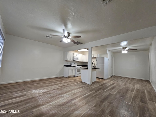 kitchen featuring white appliances, a textured ceiling, ceiling fan, white cabinets, and hardwood / wood-style flooring