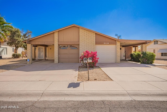 mid-century home with a garage, concrete driveway, and brick siding