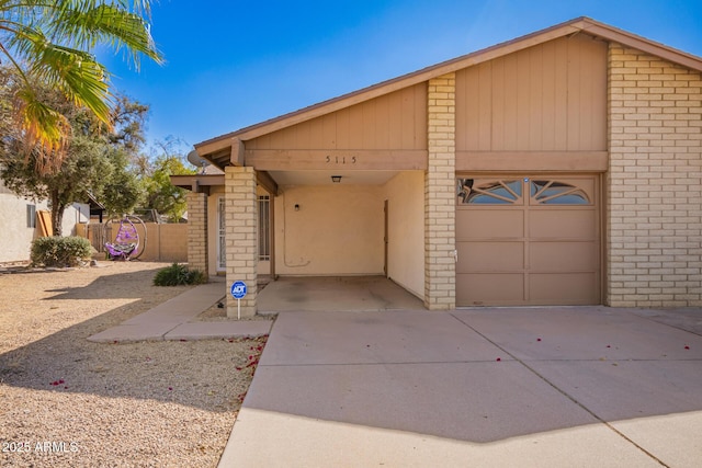 view of front of house featuring a carport, concrete driveway, and fence