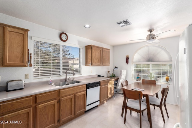 kitchen with white dishwasher, ceiling fan, sink, and a textured ceiling