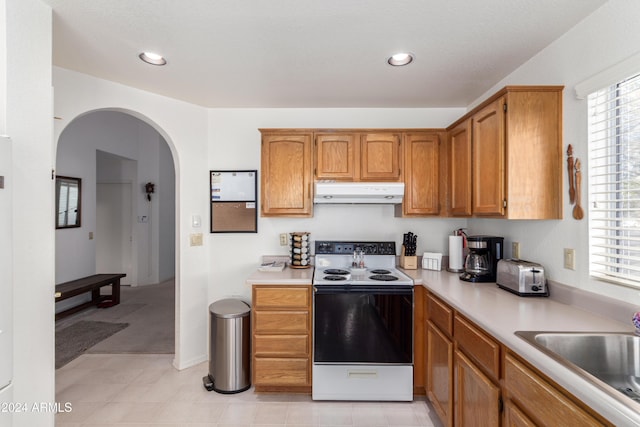 kitchen with white electric range, plenty of natural light, and sink