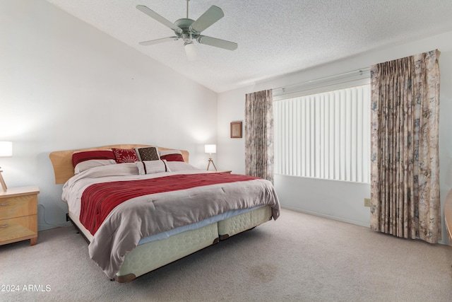 bedroom with ceiling fan, light colored carpet, a textured ceiling, and vaulted ceiling