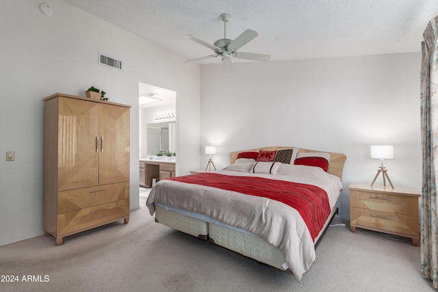 bedroom with ensuite bath, ceiling fan, carpet floors, and a textured ceiling