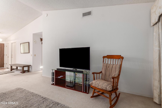 living area featuring carpet flooring, a textured ceiling, and lofted ceiling