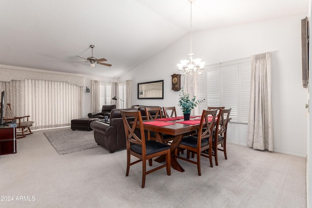 dining area with ceiling fan with notable chandelier, light colored carpet, and high vaulted ceiling