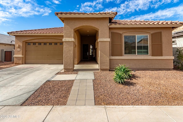 mediterranean / spanish home featuring a garage, concrete driveway, and stucco siding