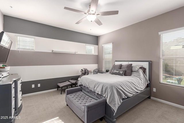 bedroom featuring a ceiling fan, light colored carpet, and baseboards