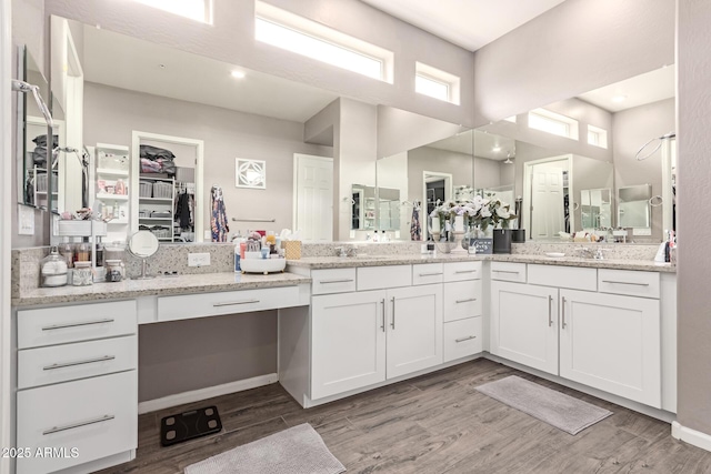 full bathroom featuring a spacious closet, wood finished floors, and vanity