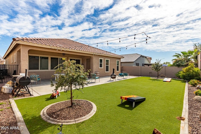 back of property featuring a tile roof, a patio, a lawn, and stucco siding