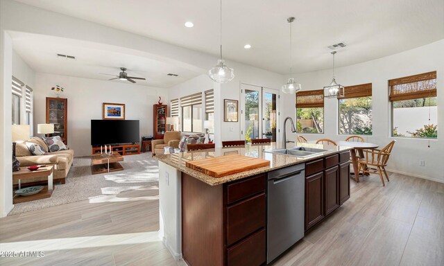 kitchen with dishwasher, a center island with sink, sink, hanging light fixtures, and ceiling fan