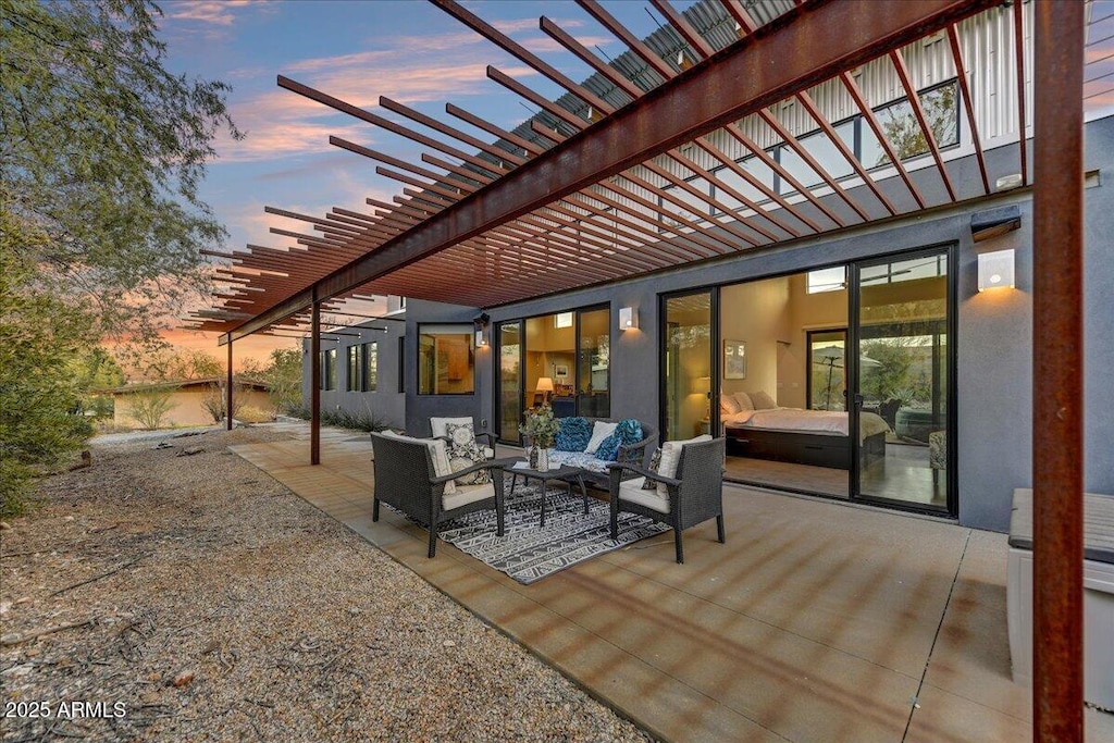 patio terrace at dusk featuring a pergola and an outdoor hangout area