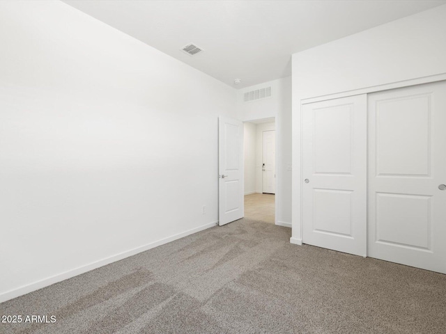 unfurnished bedroom with visible vents, carpet floors, baseboards, and a closet