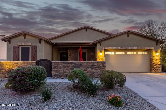 14204 S 179th Ln, Goodyear, AZ 85338 - view of front of house with concrete driveway, stucco siding, stone siding, an attached garage, and fence