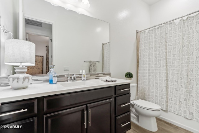 14204 S 179th Ln, Goodyear, AZ 85338 - bathroom featuring vanity, toilet, visible vents, decorative backsplash, and wood finished floors