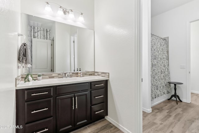 14204 S 179th Ln, Goodyear, AZ 85338 - full bathroom with decorative backsplash, a shower with shower curtain, vanity, and wood finished floors