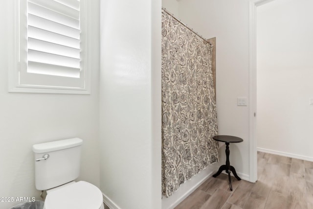 14204 S 179th Ln, Goodyear, AZ 85338 - bathroom featuring toilet, curtained shower, wood finished floors, and baseboards