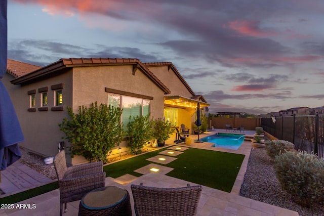14204 S 179th Ln, Goodyear, AZ 85338 - pool at dusk with a fenced in pool, a patio, and a fenced backyard