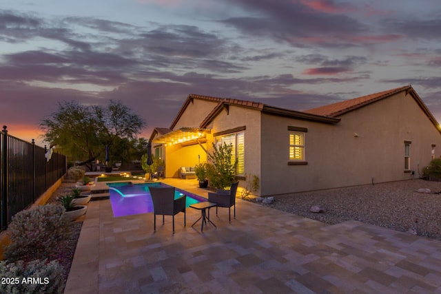 14204 S 179th Ln, Goodyear, AZ 85338 - exterior space with a patio, stucco siding, an outdoor hangout area, a tiled roof, and fence