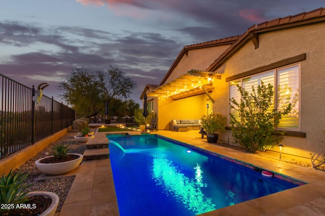 14204 S 179th Ln, Goodyear, AZ 85338 - pool at dusk with a fenced in pool, an outdoor living space, a patio, and fence