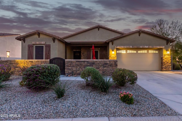 14204 S 179th Ln, Goodyear, AZ 85338 - view of front of house featuring concrete driveway, stone siding, a garage, and stucco siding