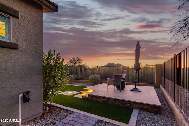 14204 S 179th Ln, Goodyear, AZ 85338 - yard at dusk featuring a patio area and a fenced backyard