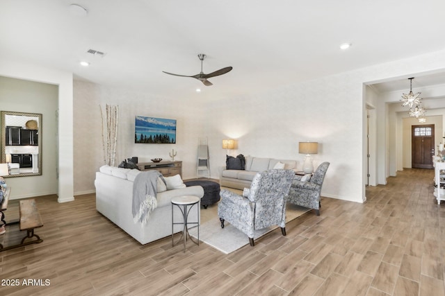 14204 S 179th Ln, Goodyear, AZ 85338 - living room with light wood-style flooring, ceiling fan with notable chandelier, baseboards, and visible vents