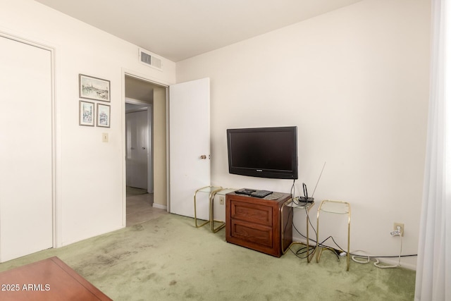 living area with visible vents and light colored carpet